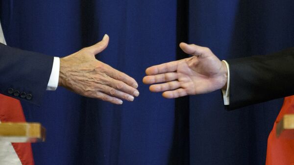 Secretario de Estado de EEUU, John Kerry, y ministro de Exteriores de Rusia, Serguéi Lavrov estrechan las manos - Sputnik Mundo