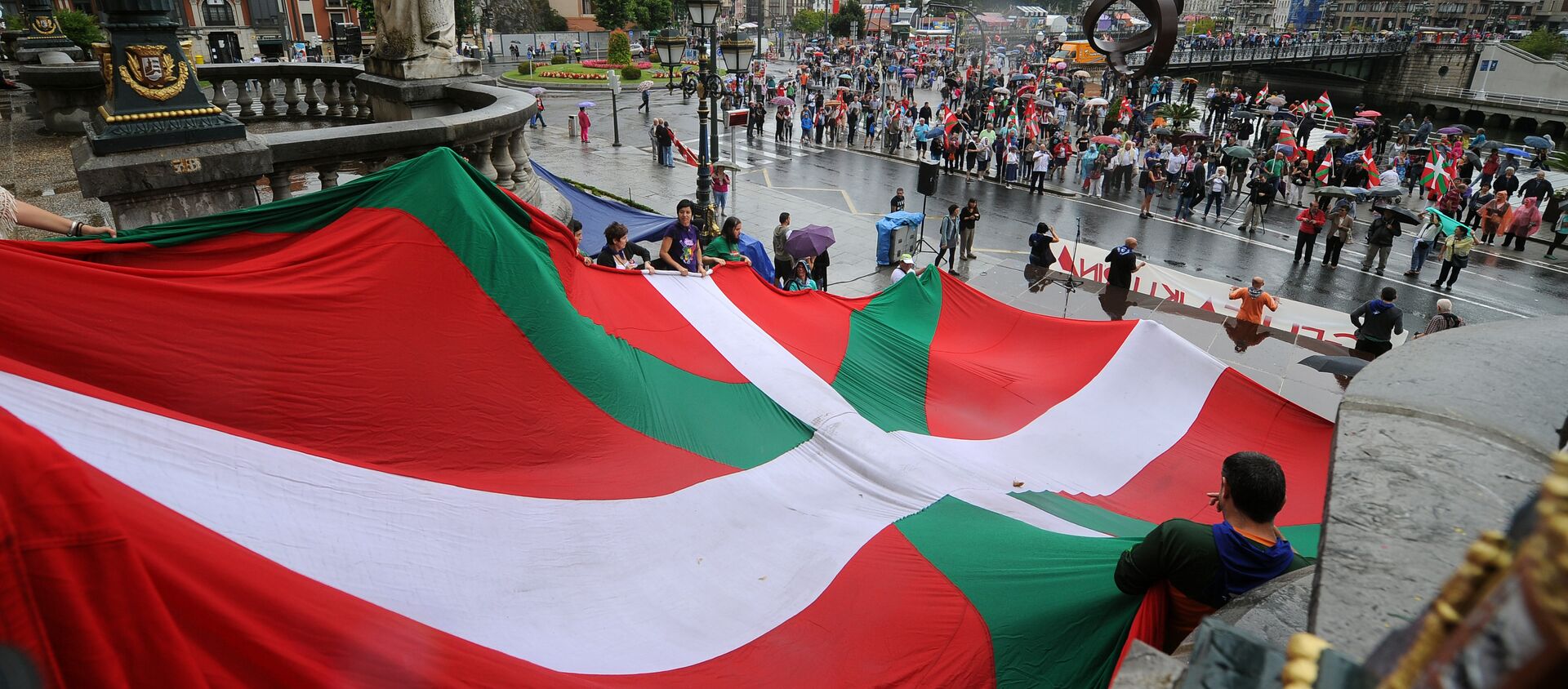 Pro independence demonstrators hold a big Ikurrina (Basque flag) at the entrance of the northern Spanish Basque city of Bilbao's Town Hall as they protest in favour of the Basque flag (Ikurrina) - Sputnik Mundo, 1920, 28.01.2021
