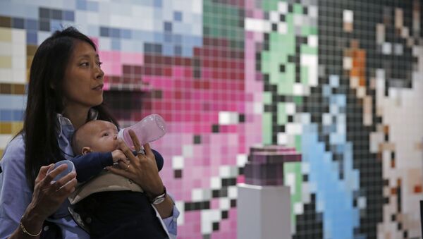 A woman feeds her baby in front of an art installation created by German artist Tobias Rehberger during the VIP preview of the art fair Art Basel in Hong Kong, - Sputnik Mundo