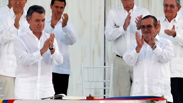El presidente colombiano, Juan Manuel Santos, y el líder de las FARC, Rodrigo Londoño alias Timochenko  durante la firma del Acuerdo Final sobre la Paz en Cartagena, el 26 de septiembre de 2016 - Sputnik Mundo