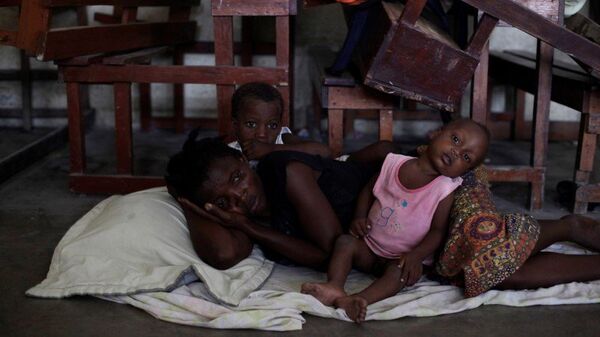 Mujer con dos niños en un refugio por el huracán Matthew en Haití - Sputnik Mundo