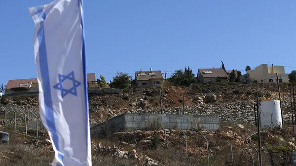 An Israeli national flag flying next to an Israeli building site of new housing units in the Jewish settlement of Shilo in the occupied Palestinian West Bank - Sputnik Mundo