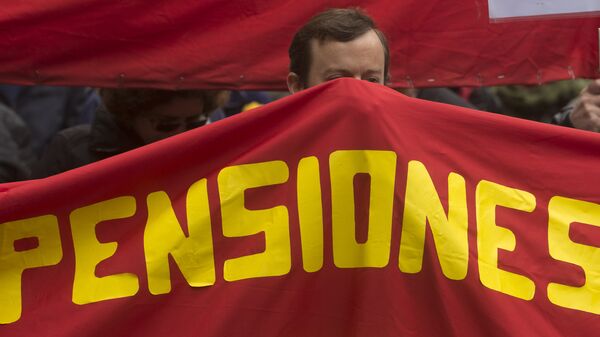 Un trabajador camina detrás de una pancarta que dice: Pensiones durante una marcha en Madrid, España, el miércoles 1 de mayo de 2013. - Sputnik Mundo