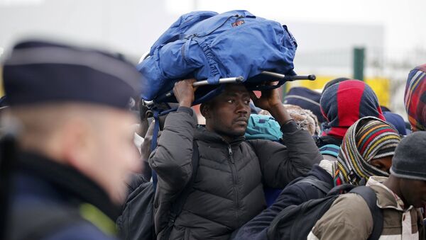 Un migrante espera la evacuación de campamento de Calais - Sputnik Mundo