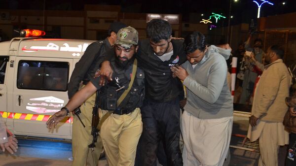 A Pakistani volunteer and a police officer rush an injured person to a hospital in Quetta, Pakistan - Sputnik Mundo