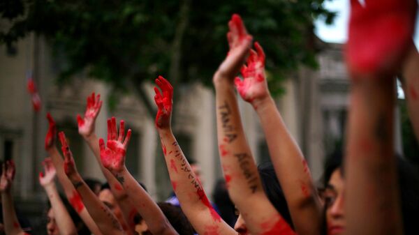 Demonstrators rise their painted hands during a peaceful march against gender violence in Santiago, Chile - Sputnik Mundo