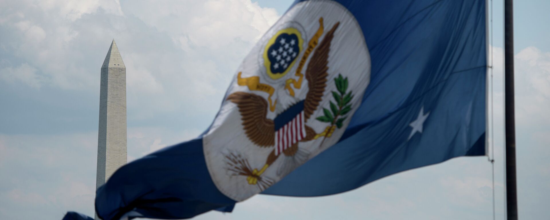 The Washington Monument is seen beyond the US State Department's flag June 30, 2015 in Washington, DC - Sputnik Mundo, 1920, 23.06.2022