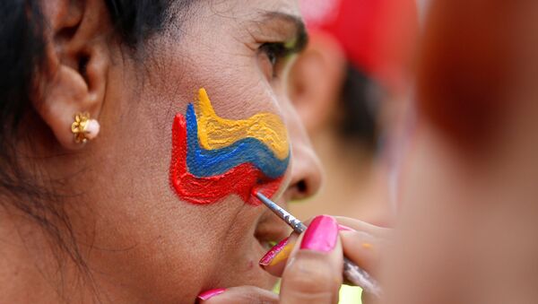 Mujer con una bandera de Venezuela pintada en el rostro - Sputnik Mundo