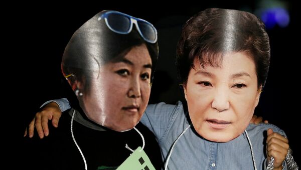 Manifestantes surcoreanos con las fotos de Choi Soon-sil, y la expresidenta del país, Park Geun-hye (archivo) - Sputnik Mundo