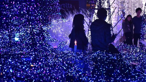 Люди среди рождественской иллюминации Каретта в Токио  - Sputnik Mundo
