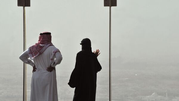 A Saudi couple look from above at the sand and dust storm in the Saudi capital Riyadh - Sputnik Mundo