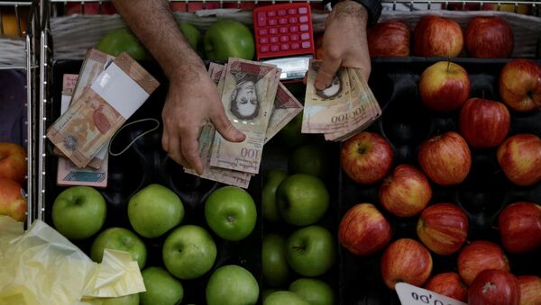 A cashier counts Venezuelan bolivar notes at a market in downtown Caracas, Venezuela - Sputnik Mundo