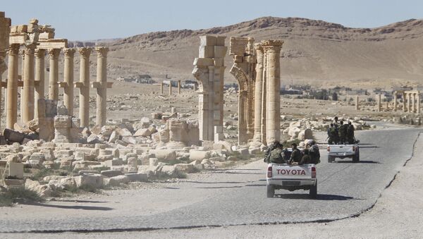 Syrian army soldiers drive past the Arch of Triumph in the historic city of Palmyra, in Homs Governorate, Syria - Sputnik Mundo