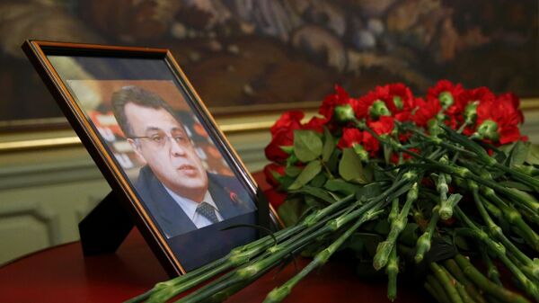 Flowers are placed near a portrait of murdered Russian ambassador to Turkey Karlov during a meeting of Russian Foreign Minister Lavrov with his Turkish counterpart Cavusoglu in Moscow - Sputnik Mundo