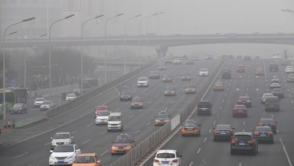 Smog hangs over a road on a polluted day in Beijing on December 20, 2016. Heavy smog suffocated northeast China for a fifth day on December 20, with hundreds of flights cancelled and road and rail transport grinding to a halt under the low visibility conditions. - Sputnik Mundo