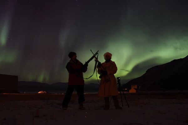 Sasha con su colega-guía con aurora boreal de fondo Sasha con su colega-guía con aurora boreal de fondo - Sputnik Mundo