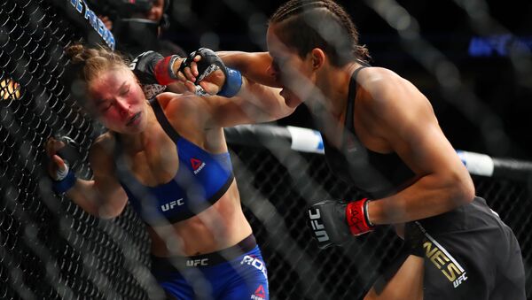 Amanda Nunes lands punches while Ronda Rousey is against the cage during UFC 207 - Sputnik Mundo