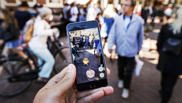 Gamers play with the Pokemon Go application on their mobile phone, at the Grote Markt in Haarlem, on July 13, 2016 - Sputnik Mundo