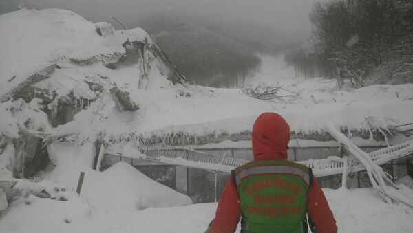 Un socorrista enfrente del hotel destruido por avalancha, Italia - Sputnik Mundo