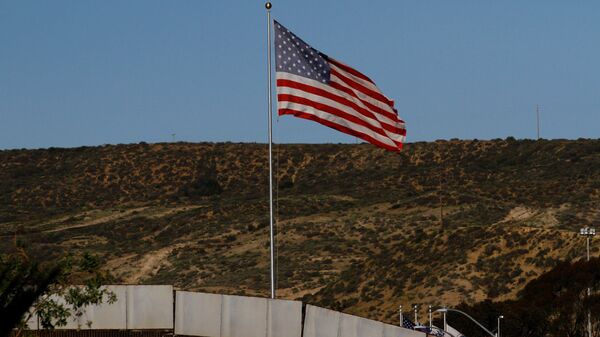 A U.S. flag is seen next to a section of the wall separating Mexico and the United States, in Tijuana, Mexico, January 28, 2017 - Sputnik Mundo