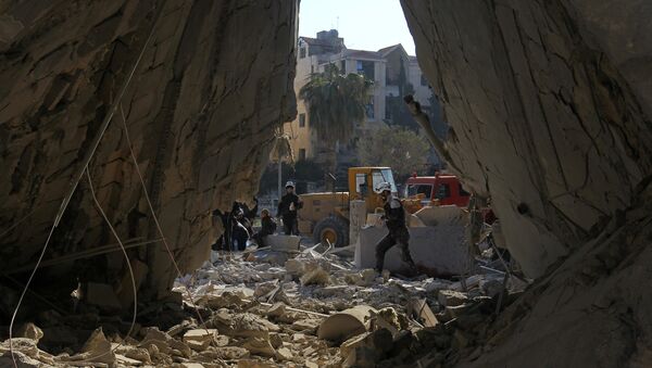 Civil defense members work at a site hit by airstrikes in the rebel-held city of Idlib, Syria - Sputnik Mundo