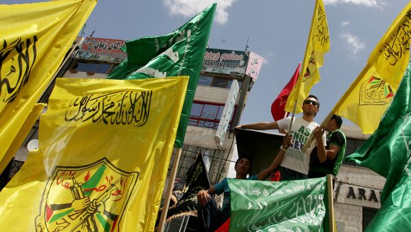 Palestinian supporters of Hamas Islamist movement and of Fatah party wave their faction's flags during a rally to support the Palestinian political unity deal, in the West Bank city of Jenin. (File) - Sputnik Mundo