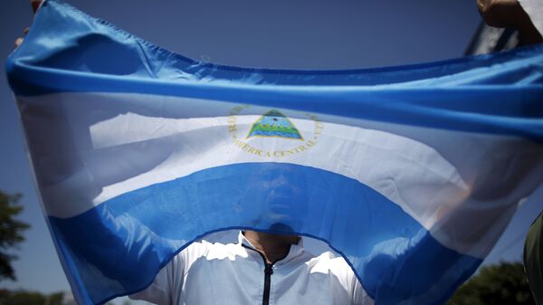 A man holds up a Nicaraguan flag during a demonstration against the presidential candidacy of Nicaragua's President Daniel Ortega in Managua, Nicaragua, Sunday, Feb 20, 2011.  - Sputnik Mundo