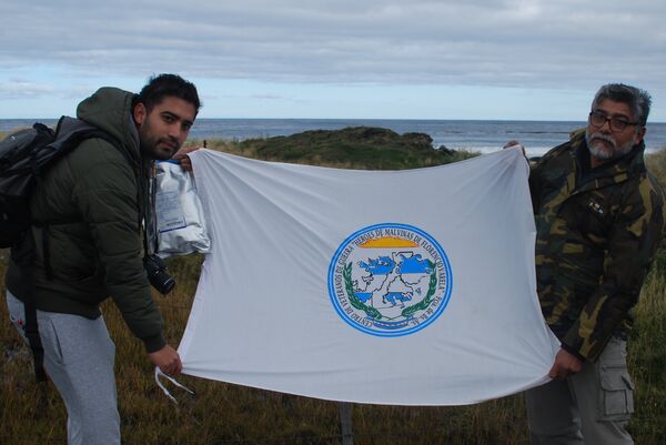 El excombatiente de la Guerra de Malvinas Armando González y su hijo Martín sostienen una bandera El excombatiente de la Guerra de Malvinas Armando González y su hijo Martín sostienen una bandera - Sputnik Mundo