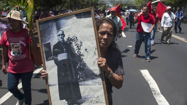 Una mujer sostiene retrato del Monseñor Óscar Romero asesinado en la década de los 80 - Sputnik Mundo