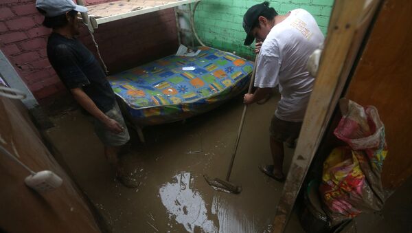 Peruanos limpian sus casa tras las inundaciones - Sputnik Mundo