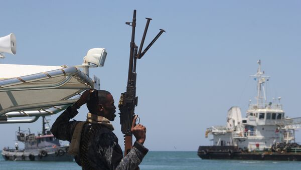 A maritime policeman on a tag-boat guards oil tanker Aris-13, which was released by pirates, as it sails to dock on the shores of the Gulf of Aden in the city of Bosasso, northern Somalia's semi-autonomous region of Puntland, March 19, 2017 - Sputnik Mundo