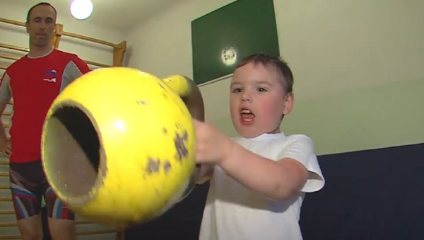 Un niño de 4 años levantando pesas - Sputnik Mundo