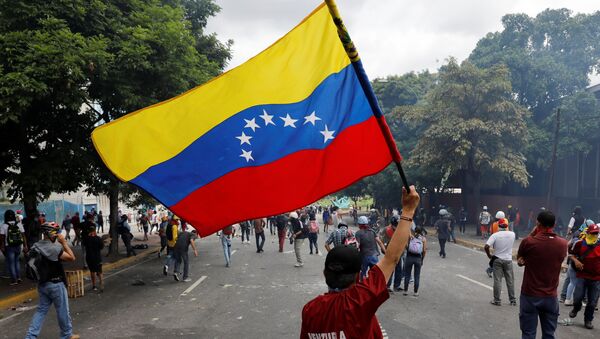 Un manifestante con la bandera de Venezuela - Sputnik Mundo