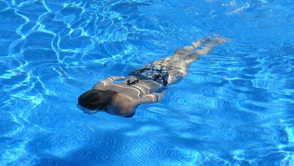 Una mujer en una piscina - Sputnik Mundo
