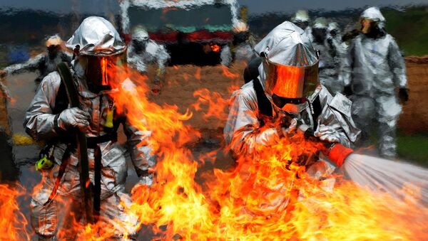 Unos bomberos intentan apagar el fuego (imagen referencial) - Sputnik Mundo