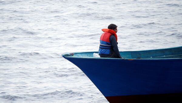 Un migrante en el barco en el Mediterráneo - Sputnik Mundo