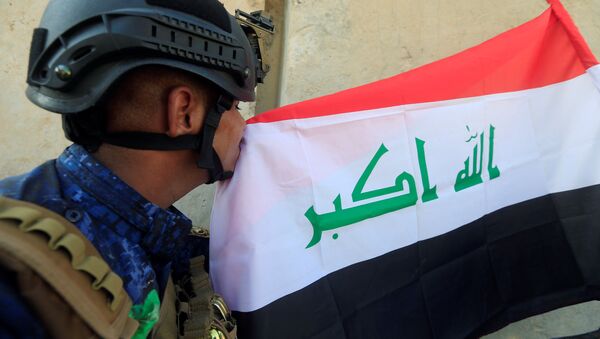 Un militar iraquí besa la bandera del país - Sputnik Mundo