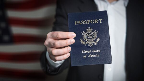Un hombre sostiene un pasaporte estadounidense - Sputnik Mundo