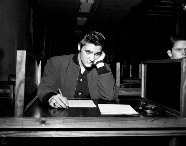 El cantante Elvis Presley, de 21 años, toma su examen escrito de preinducción cuando está procesado por el Ejército de EEUU en Memphis, estado de Tennessee, el 4 de enero de 1957. - Sputnik Mundo