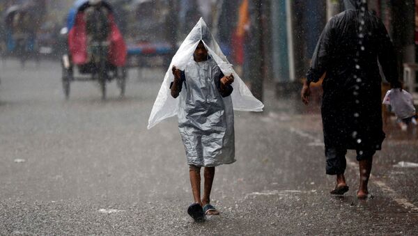 Un chico bajo la lluvia en Bangladés - Sputnik Mundo