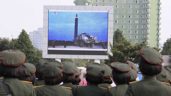 Los norcoreanos observan en una pantalla el lanzamiento del misil balístico - Sputnik Mundo