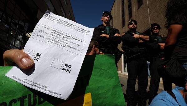 Un manifestante sujeta una papeleta del referéndum catalán frente a los agentes de la Guardia Civil - Sputnik Mundo