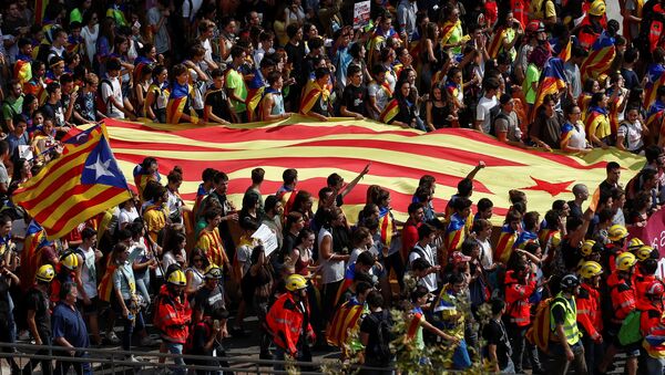 Estudiantes llevan una bandera separatista catalana mientras asisten a una manifestación en favor del referéndum de independencia - Sputnik Mundo