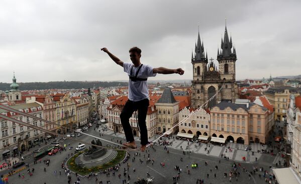 Un funámbulo realiza ejercicios sobre la cuerda floja en la plaza de la Ciudad Vieja de Praga - Sputnik Mundo