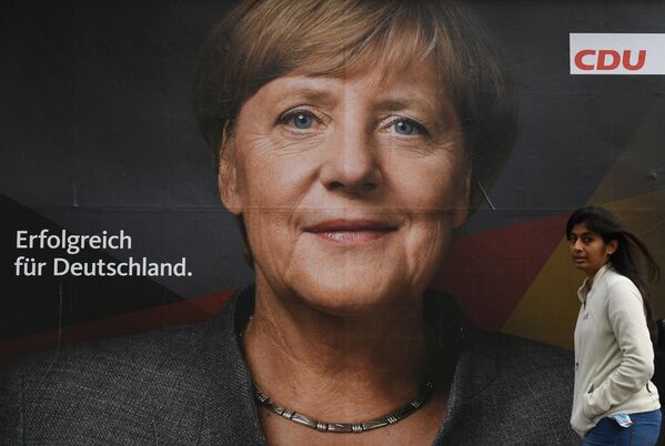 Un cartel con la foto de la canciller de Alemania, Angela Merkel - Sputnik Mundo