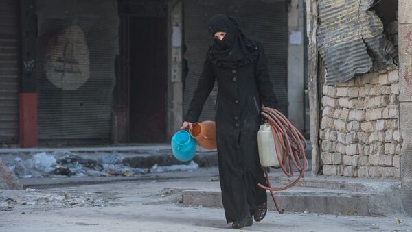 Una mujer camina en una zona residencial de una ciudad siria (imagen referencial) - Sputnik Mundo