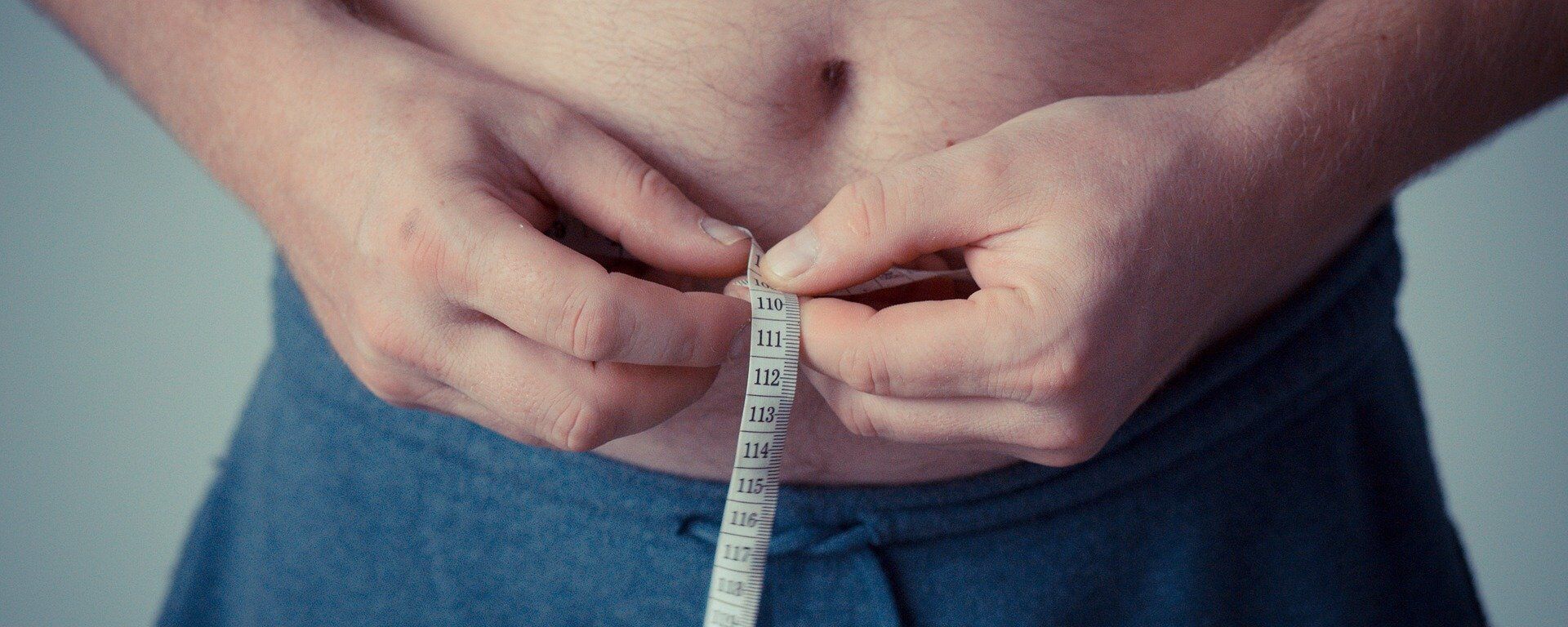 Un hombre se mide la barriga con una cinta métrica Un hombre se mide la barriga con una cinta métrica - Sputnik Mundo, 1920, 24.12.2018