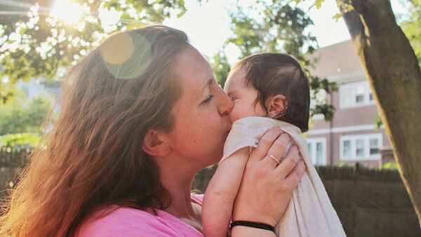 Madre besa a su bebé - Sputnik Mundo