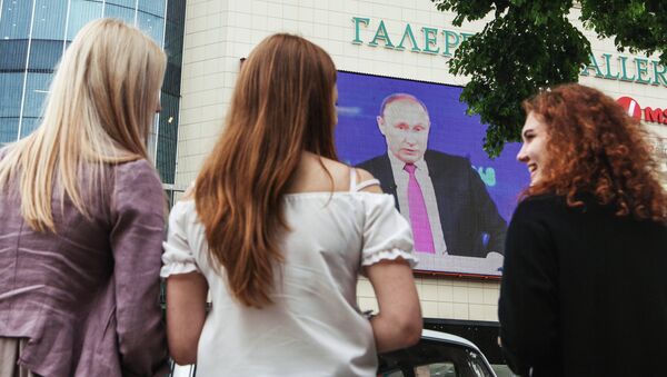 Unas jóvenes rusas están viendo un discurdo del presidente de Rusia, Vladímir Putin, por la televisión - Sputnik Mundo