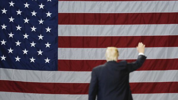 El presidente de EEUU, Donald Trump, con la bandera del país al fondo - Sputnik Mundo